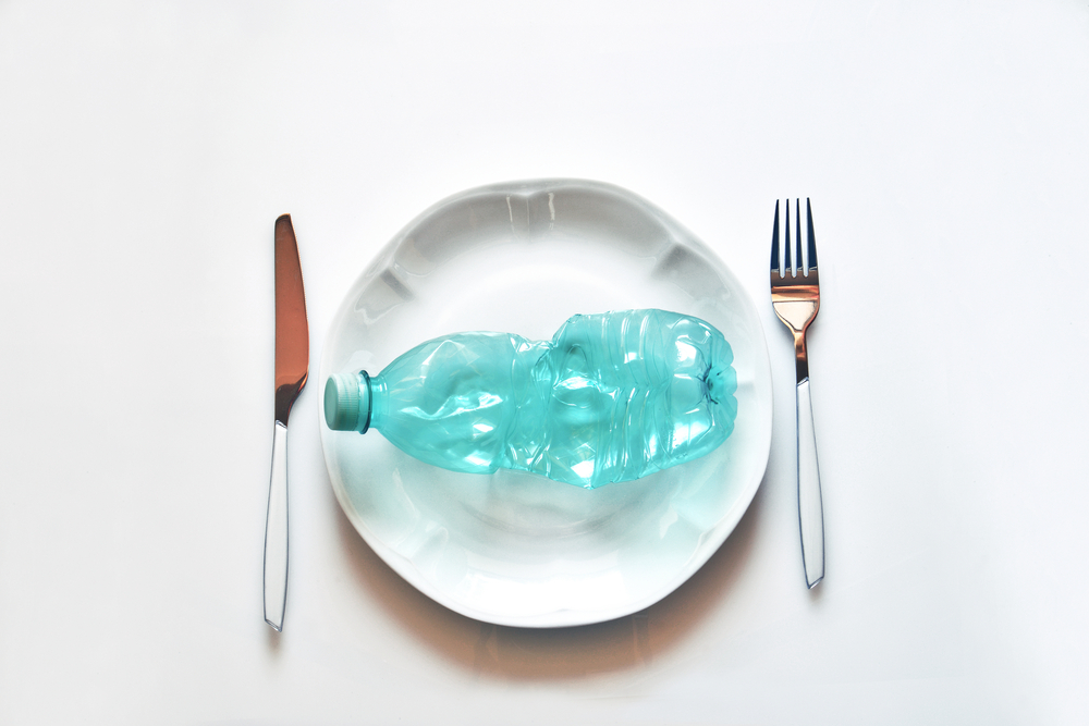 Bord met plastic, symbool voor 'plastic eten' en de aanwezigheid van microplastics in ons voedsel.
